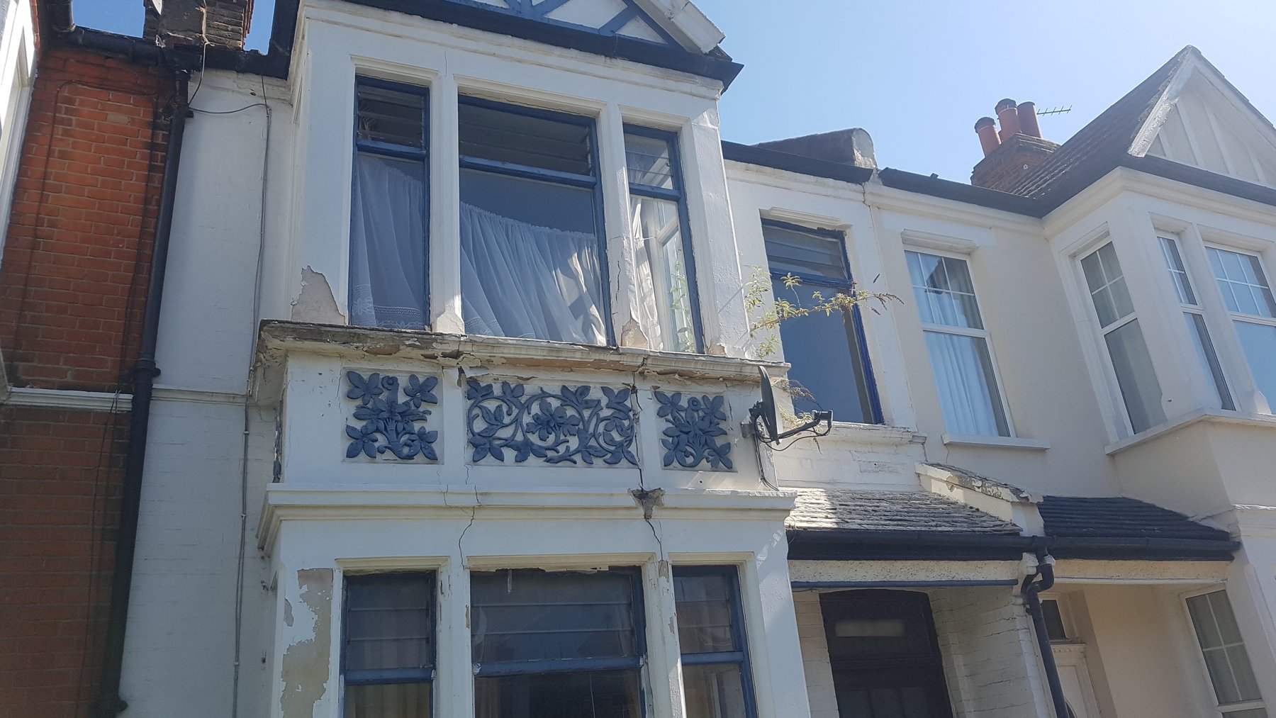 Front of the terrace before work, with peeling paint and damaged bay panels