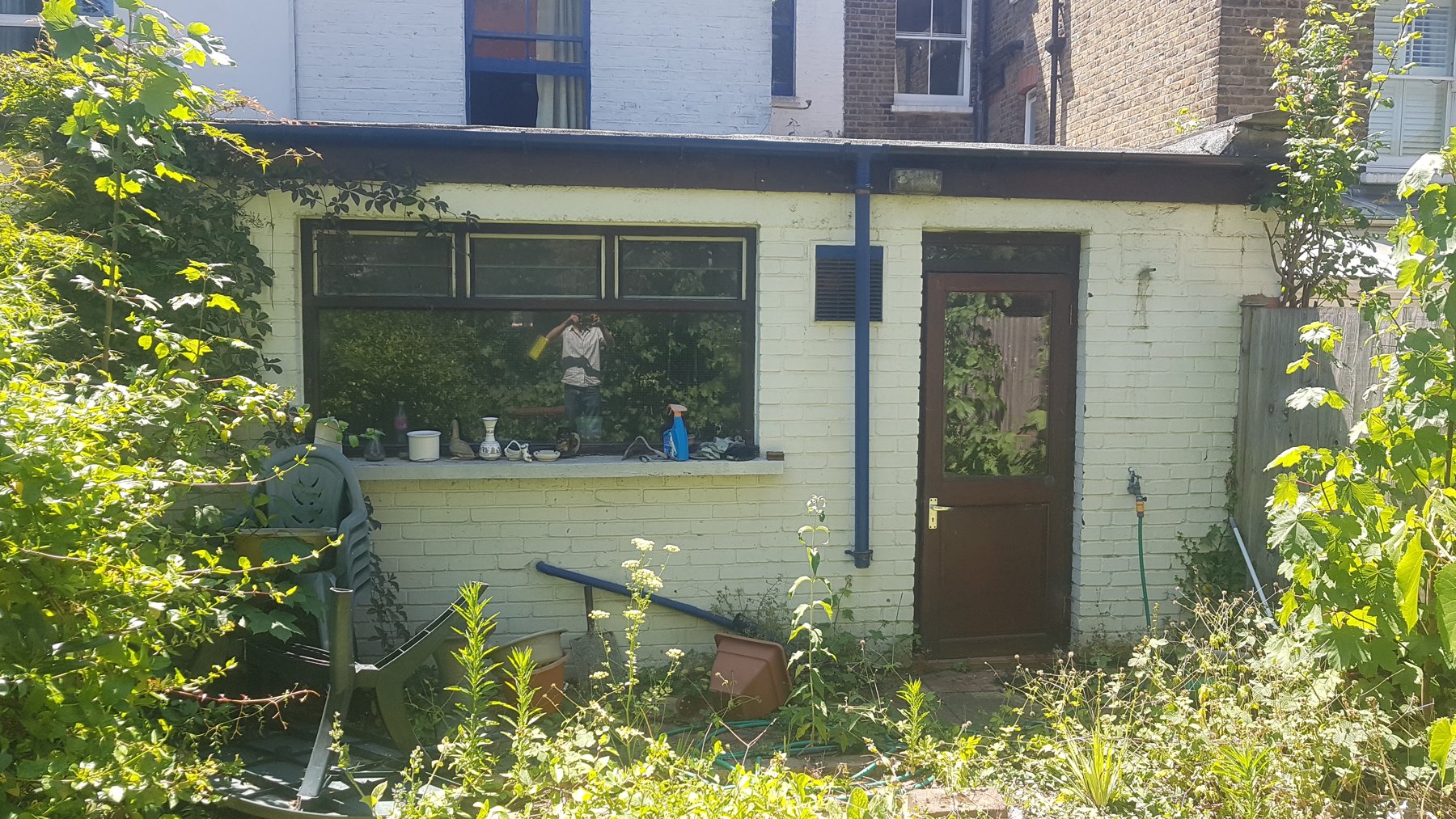 Rear of the terrace before work, with an old lean-to and overgrown garden