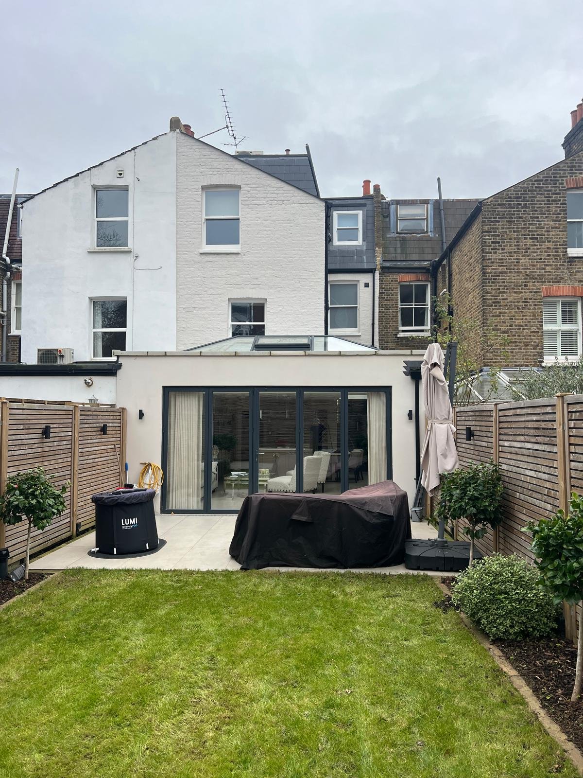 Completed rear extension with wide glazed doors, a new garden and a mansard roof