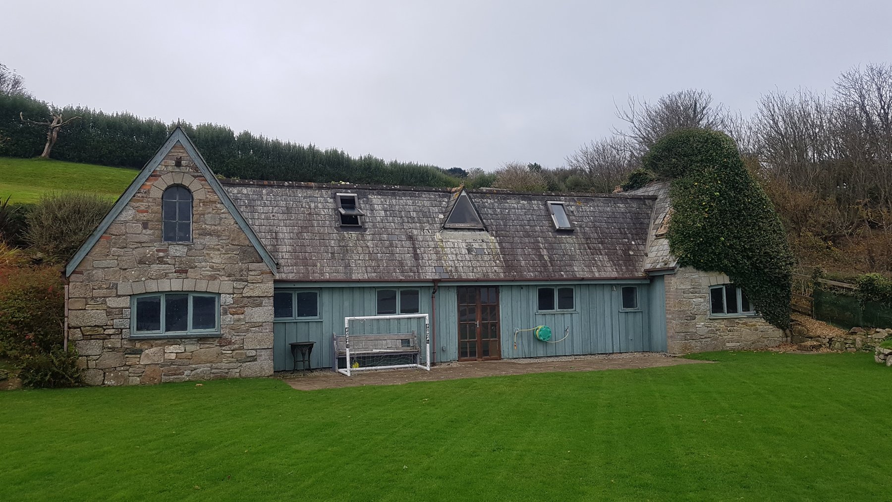 The stone and timber outbuilding before conversion, used for storage